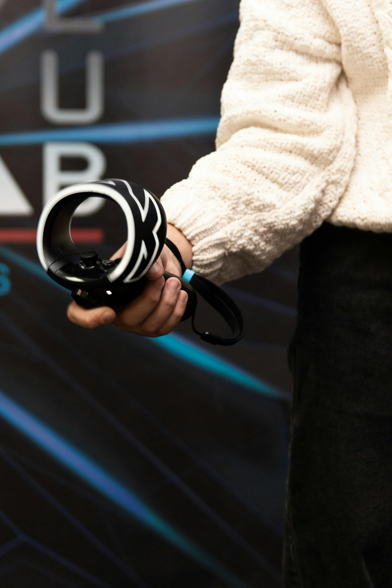 Close-up of a hand holding a modern gaming controller against a blurred background.
